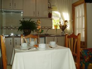 a table with cups and saucers on it in a kitchen at Apartamentos Jucar - Hotel Rural in Tragacete