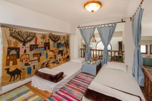 1 dormitorio con 2 camas y un mural en la pared en White Villa en Pastida