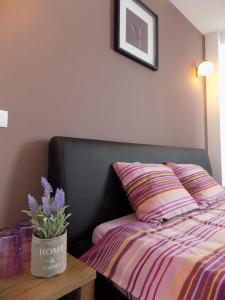 a bedroom with a bed and a table with a flower pot at Colosseum Residence in Bucharest