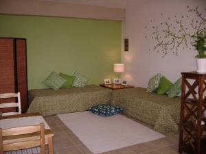 two beds in a room with green walls at Gidalia Villa in Gouvia