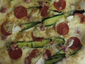 a pizza with pepperoni and asparagus on it at Affittacamere Porticciolo in Castelnuovo del Garda