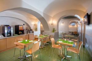 ローマにあるHotel Dei Milleのテーブルと椅子のあるレストラン、キッチンが備わります。