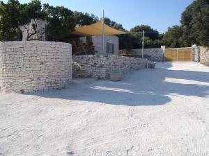 a building with a stone wall and a yellow umbrella at La casa Bianca in Bonifacio