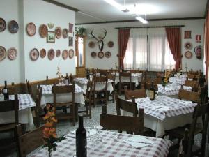 a dining room with tables and chairs with white tablecloths at Apartamentos Jucar - Hotel Rural in Tragacete