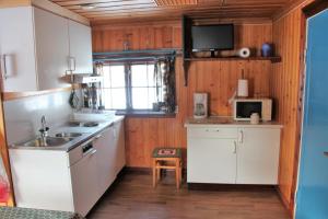 a kitchen with white cabinets and a sink and a microwave at Värnäs Camping in Stöllet