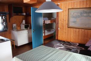 StölletにあるVärnäs Campingのキッチン、青いドア付きのベッドが備わる客室です。