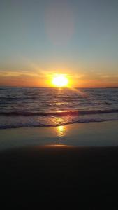 a sunset on the beach with the ocean at Casa Roma 3 Parque a 3 del solis in Parque del Plata