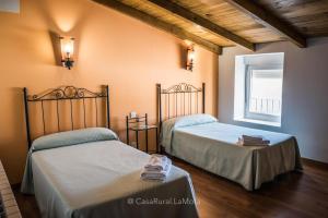 1 dormitorio con 2 camas y ventana en Casa Rural "La Mota" en Astudillo
