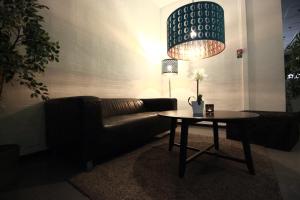 a living room with a couch and a table with a lamp at Hotell Centralstation in Uppsala