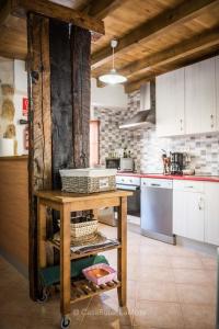 a kitchen with white cabinets and a table in it at Casa Rural "La Mota" in Astudillo