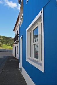 a blue building with a window on the side of it at Porto Pim Guest House in Horta
