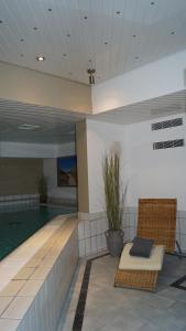 a swimming pool in a building with a chair next to a pool at Hotel Sylter Hof in Westerland (Sylt)