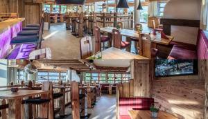 a restaurant with wooden walls and tables and chairs at die Schneiderei in Kaprun