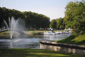 einen Fluss mit Booten in einem Park mit Brunnen in der Unterkunft Õhtu Põik 4 City Center Apartment in Pärnu