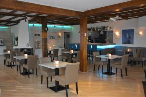 a restaurant with tables and chairs and a bar at SEA YOU Hotel Noordwijk in Noordwijk aan Zee