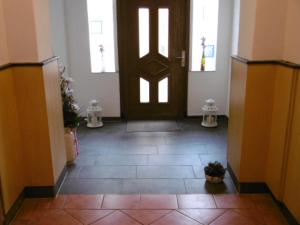 a hallway with a brown door and a tile floor at Gasthaus ,,Zum schwarzen Bär" in Güsten