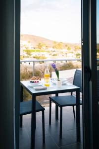 a table with a plate of food on a balcony at Cornisa Apartments in Patalavaca