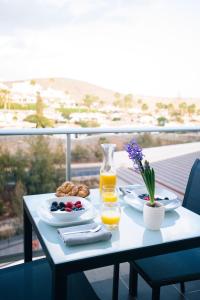 a table with food and drinks on a balcony at Cornisa Apartments in Patalavaca