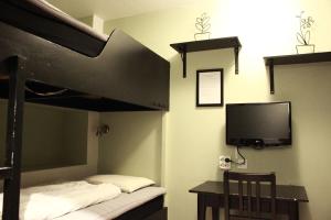 a bedroom with a bunk bed with a television and a desk at Vandrarhem Uppsala Centralstation in Uppsala