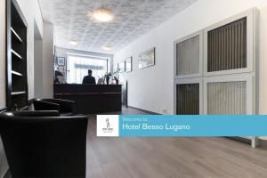 a salon with a man standing in a room at Hotel Besso Lugano Center in Lugano