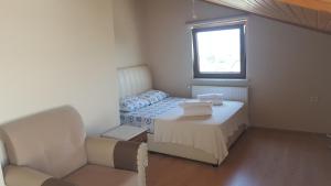 チャナッカレにあるTroya Apart Çanakkaleのベッドルーム1室(ベッド1台、テーブル、窓付)