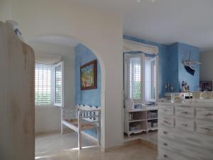een blauwe en witte kamer met een wieg en een dressoir bij Villa Riells Mar in L'Escala