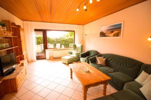 ein Wohnzimmer mit Sofa und Tisch in der Unterkunft Baltrumweg 1 in Wangerland