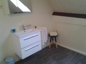 a white bathroom with a sink and a stool at Bed & Breakfast Meinsma in Moddergat +125 photos
