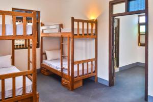 a room with four bunk beds and a doorway at zLife Stone Town in Zanzibar City