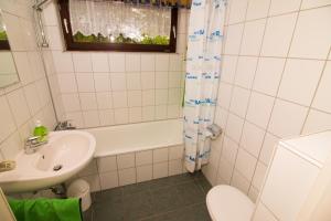ein Badezimmer mit Waschbecken, Badewanne und Toilette in der Unterkunft Baltrumweg 1 in Wangerland + 10 Fotos