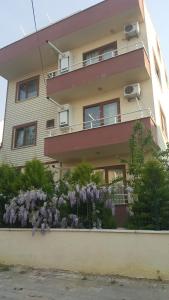 un edificio con flores púrpuras delante de él en Troya Apart Çanakkale, en Canakkale