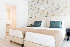 Duas camas num quarto com uma parede com borboletas em Hotel Magic em Nazaré