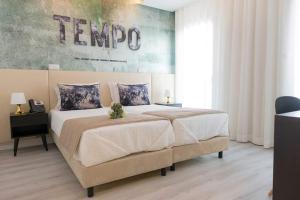 a bedroom with a large bed and a painting on the wall at Hotel Magic in Nazaré