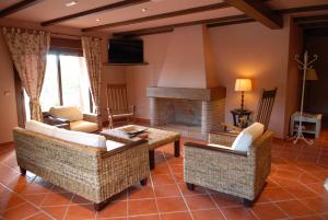 a living room with couches and a fireplace at Hotel Rural Robles in Jarandilla de la Vera