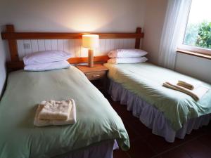 ウォータービルにあるWaterville Holiday Homes No 1のベッド2台が隣同士に設置された部屋です。