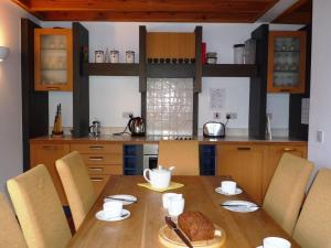 cocina con mesa de madera con sillas y comedor en Waterville Holiday Homes No 1 en Waterville