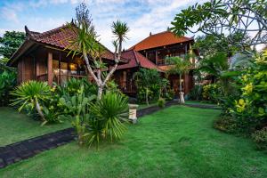 a house with a green yard in front of it at The Cozy Villas Lembongan in Nusa Lembongan