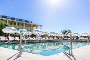 a swimming pool with lounge chairs and umbrellas at Congress Hall in Cape May