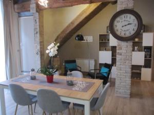 a dining room with a table and a clock on the wall at La Terracotta in Vidauban