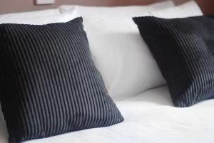 a bed with two black pillows on top of it at Waverley Hotel in Peterhead
