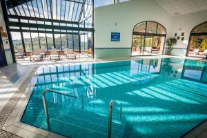 a swimming pool with blue water in a building at Le Domaine de Falgos Golf & Spa in Saint-Laurent-de-Cerdans