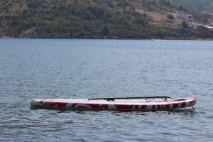 a red and white boat sitting on the water at Beach Apartments Rogoznica in Rogoznica
