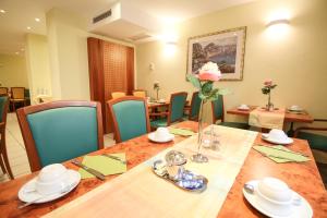 a dining room with a wooden table and blue chairs at Hotel Miramar am Römer in Frankfurt/Main