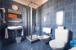 Baño de azulejos azules con aseo y lavamanos en Hotel Besso Lugano Center, en Lugano 36 fotos más