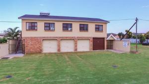 a house with two garage doors in a yard at Sundays River Mouth Guesthouse in Colchester