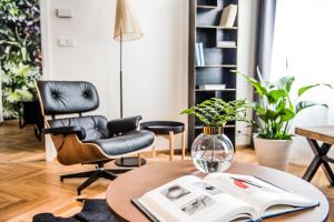 a living room with a table with a book and chairs at Masarykova N°30 in Brno