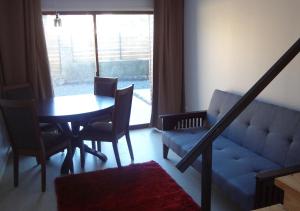 a living room with a table and chairs and a couch at Piedra Mar in El Quisco