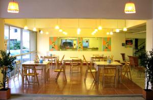 a restaurant with tables and chairs in a room at Casa Narinya @ Suvarnabhumi Airport in Lat Krabang