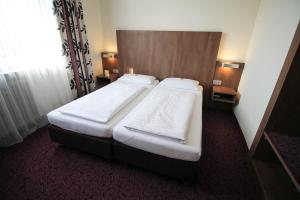 a bedroom with two beds in a hotel room at Hotel am Zoo in Frankfurt