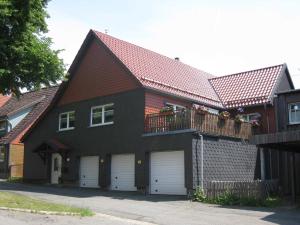 une maison avec deux portes de garage et un toit rouge dans l'établissement Ferienwohnung Becker, à Clausthal-Zellerfeld